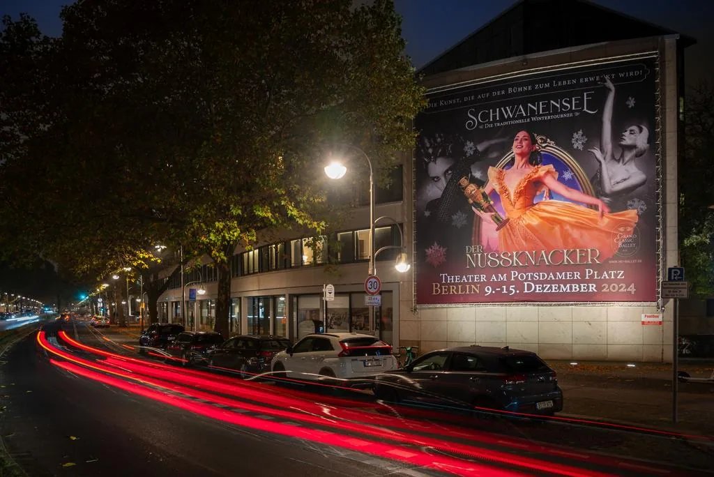 Riesenposter an einer Hausfassade am Potsdamer Platz in Berlin bei Nacht